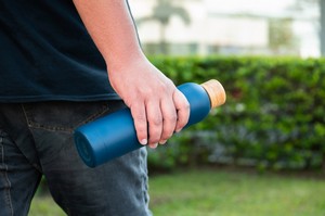 Person carrying a branded reusable bottle